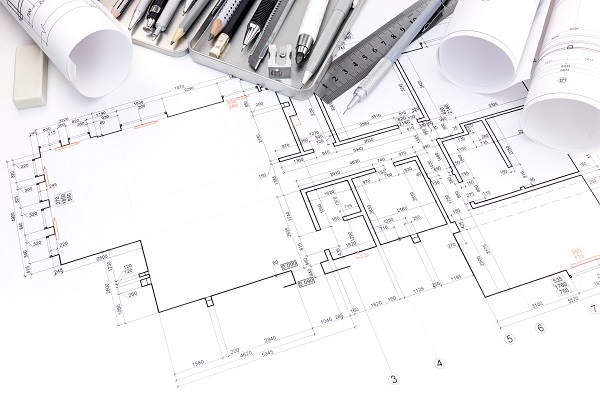 designers workplace with drawing tools and floor plan of rooms